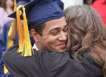 a picture of a woman hugging a recently-graduated student in celebration